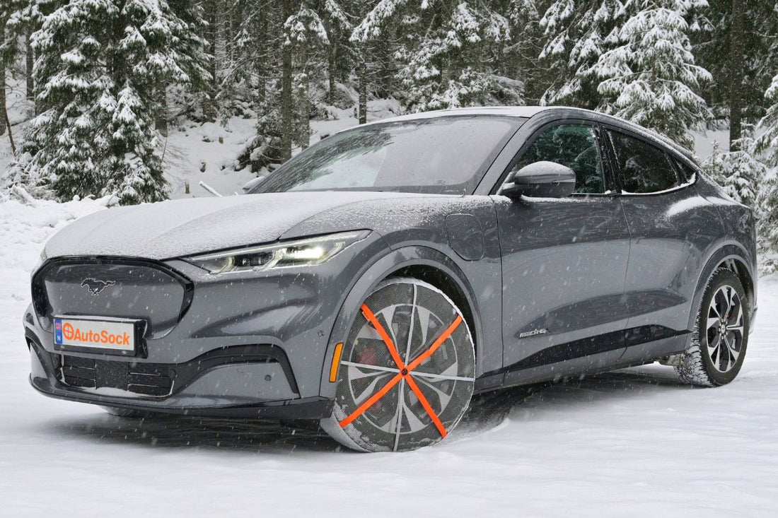 Schneesocken montiert auf den Vorderrädern eines Elektroautos Ford Mustang mach-e