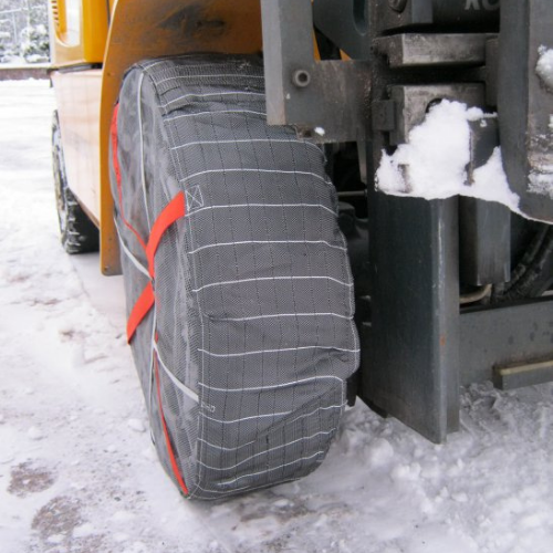 AutoSock montiert auf Vorderrad eines Gabelstaplers, stehend auf Schnee und Eis