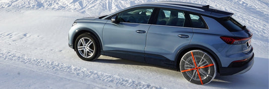 Schneeketten neu gedacht: Ein Auto mit installierten textilen Schneeketten auf den Hinterrädern